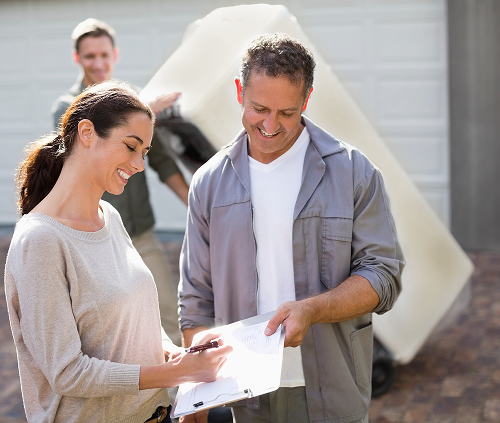 Woman signing paperwork for her appliance recycling pickup.